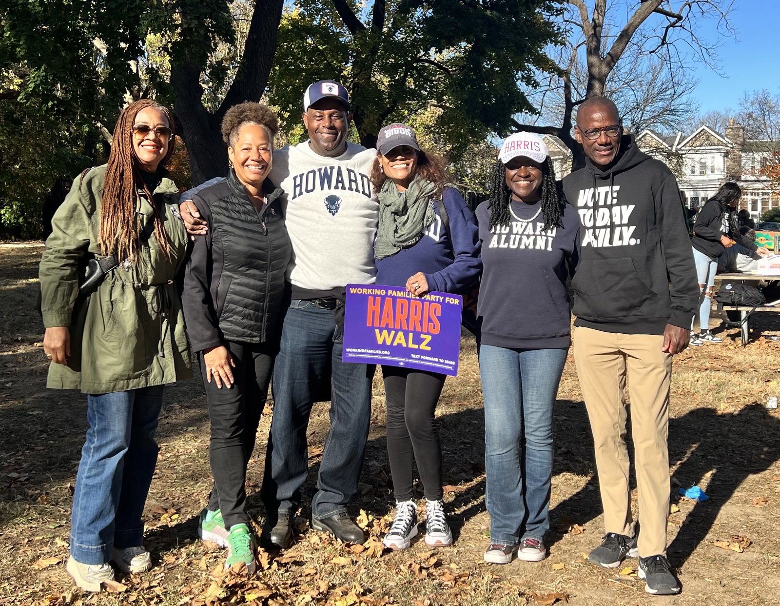 Forest Hayes and Howard University alumni holding a Harris-Walz sign while canvassing